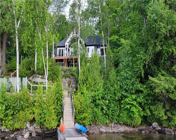 Spectacular new 4 season cottage with sunset views on prestigious Kennisis Lake! Sauna and hot tub!